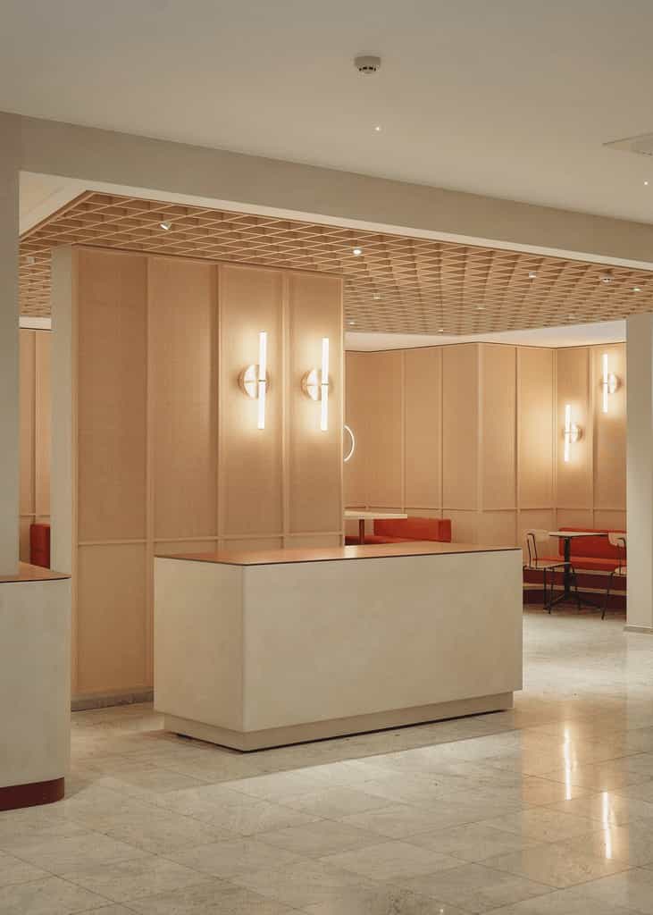 Reception or service counter in a softly lit interior with tiled flooring, wood paneling, and integrated lighting elements on the walls