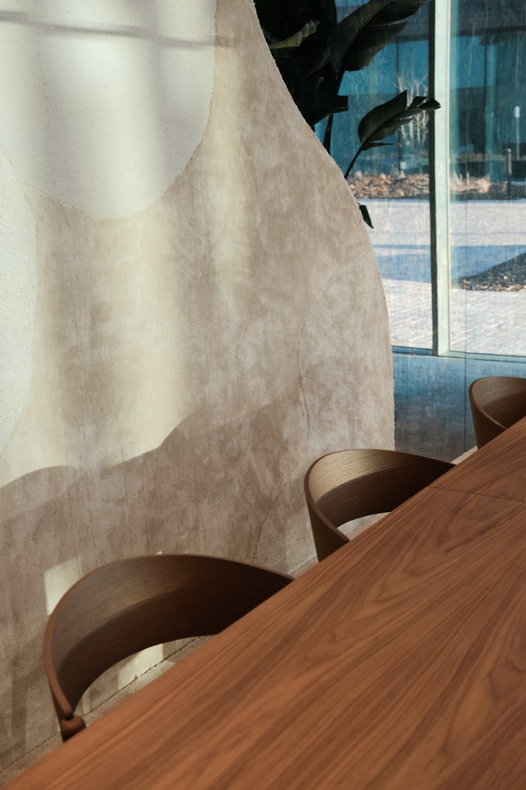 Detail of sculptural textured wall and wooden meeting chairs in the Xenon Building interior