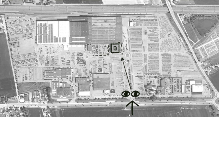 Aerial black and white view of an industrial complex with annotated arrows and eye symbols indicating a visual direction toward a central building