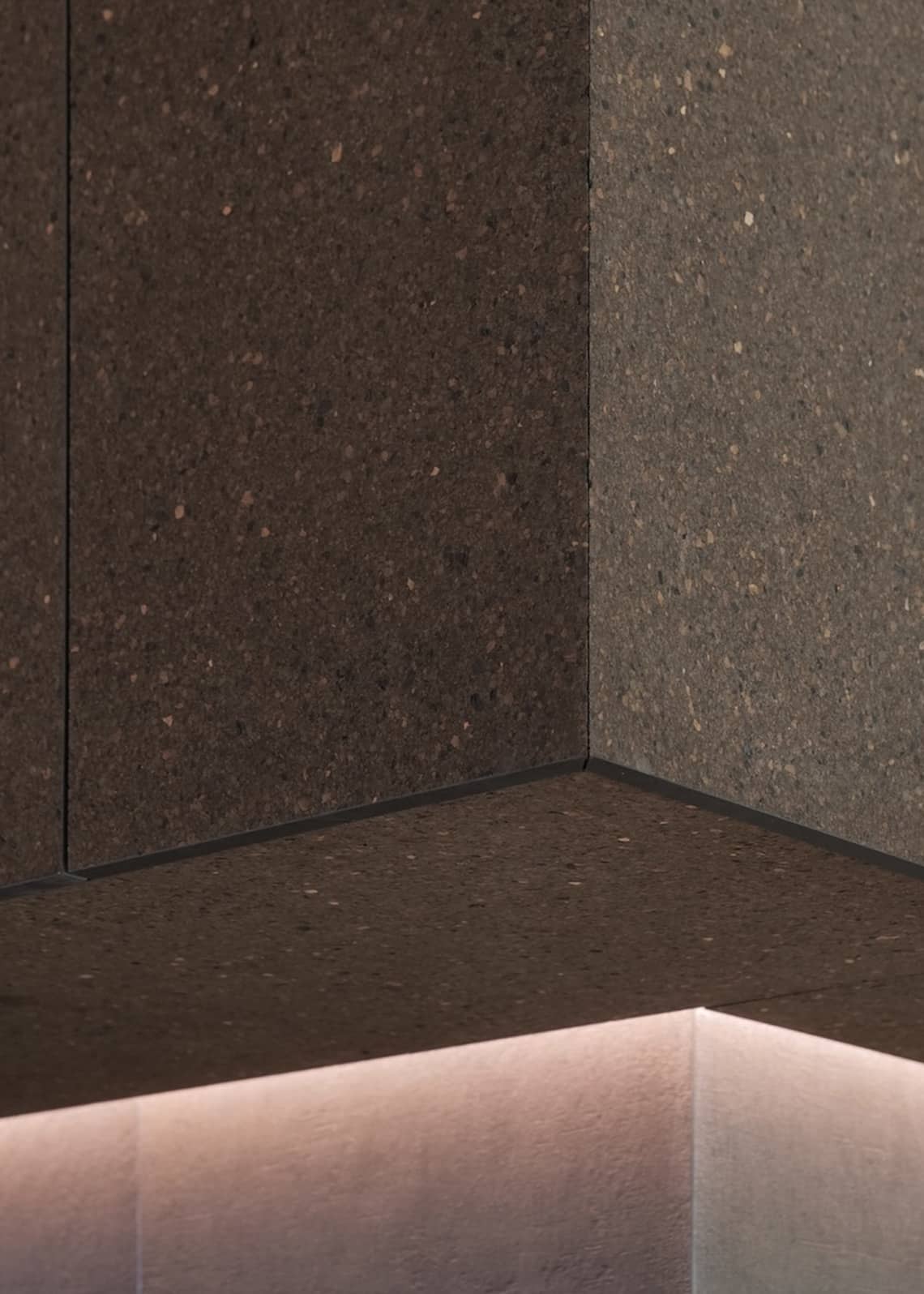 Detail of natural cork wall panels in different shades at a corner junction.