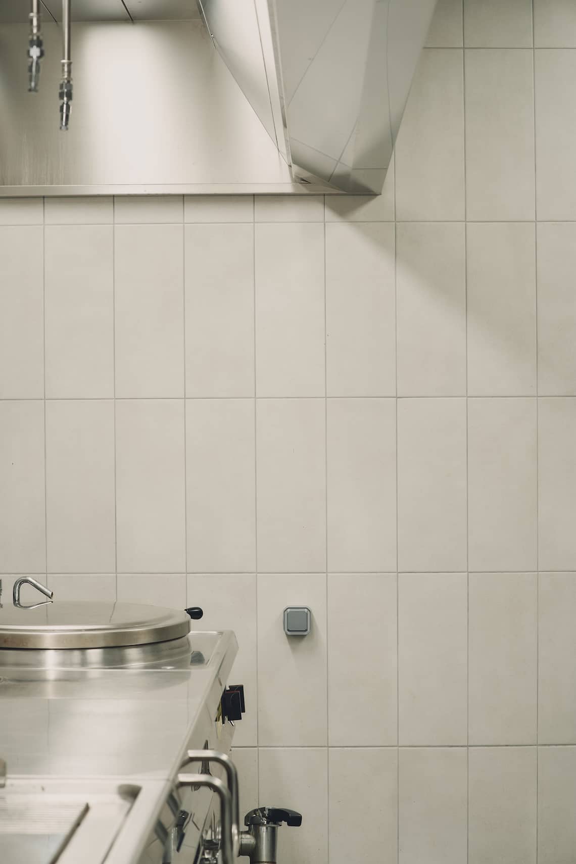 Clean industrial kitchen with chefs in uniform preparing meals inside a sustainable facility