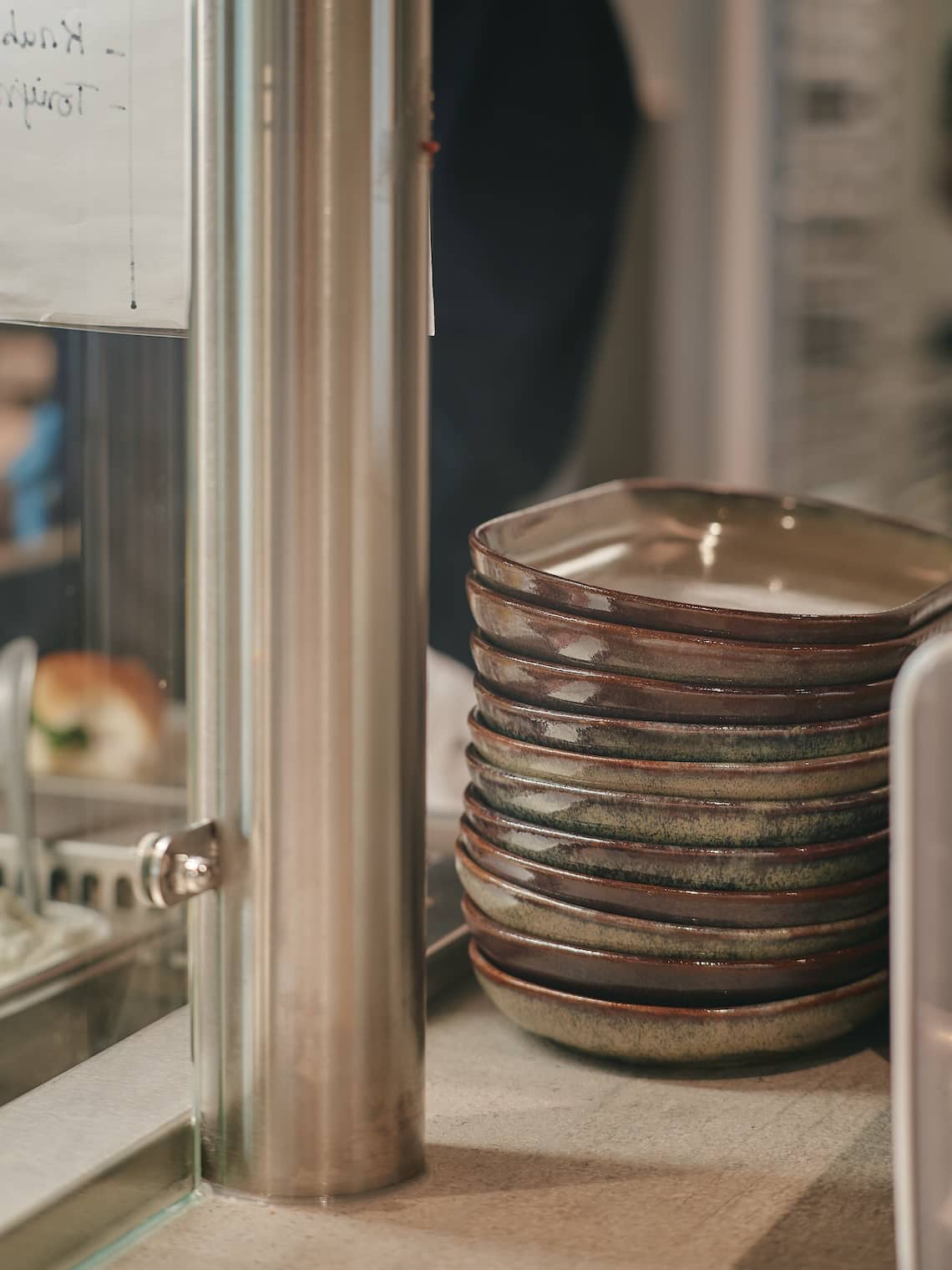 Stack of handcrafted ceramic plates at the service counter of a sustainable cafeteria