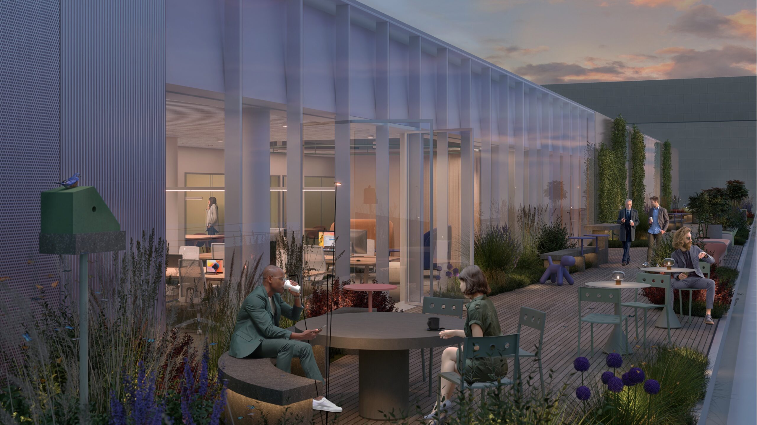 Evening rooftop terrace with people socializing and working outdoors, surrounded by greenery and illuminated by soft lighting from the office interior.